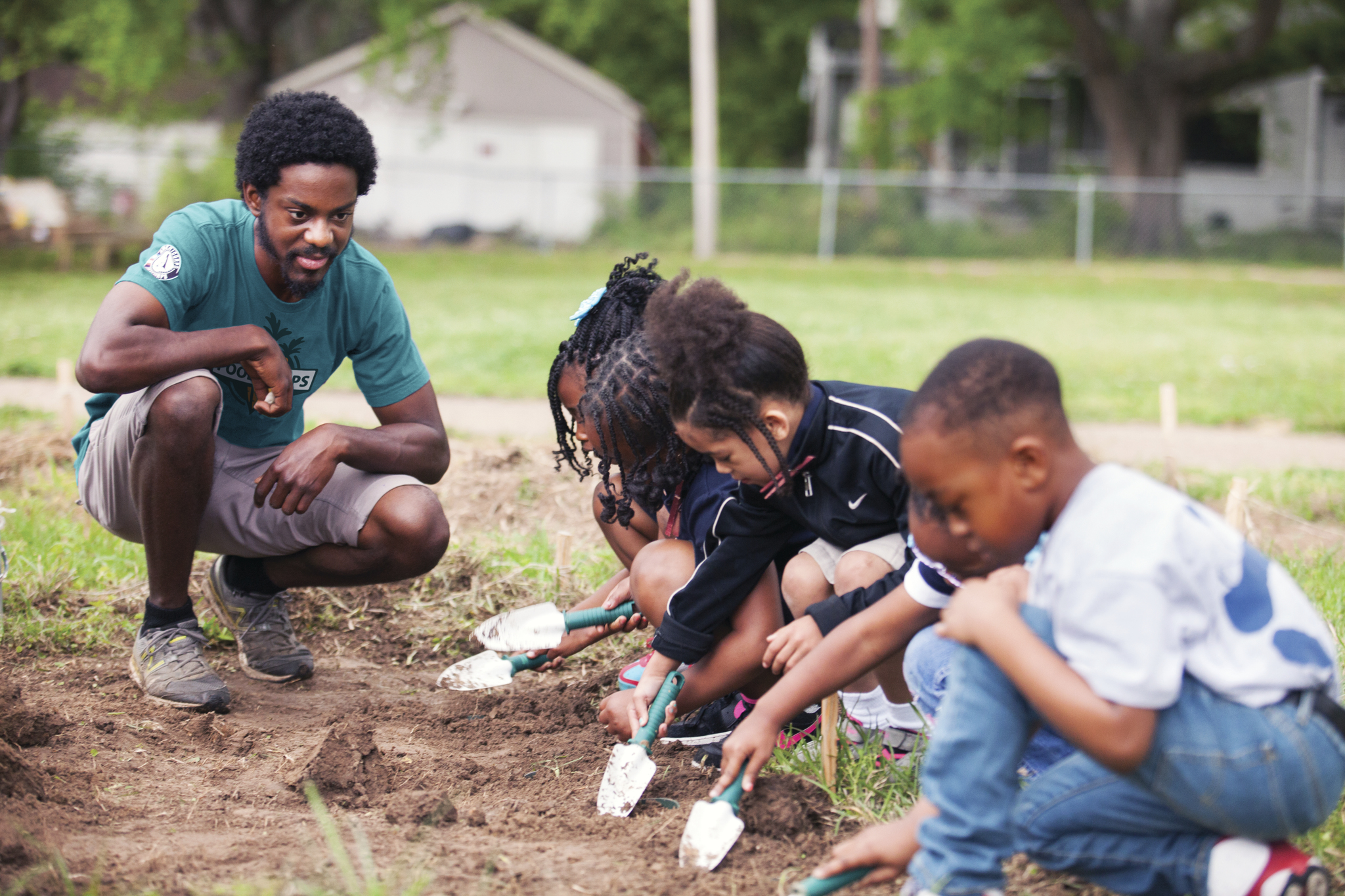 A FoodCorps service member teaches young kids in the garden.