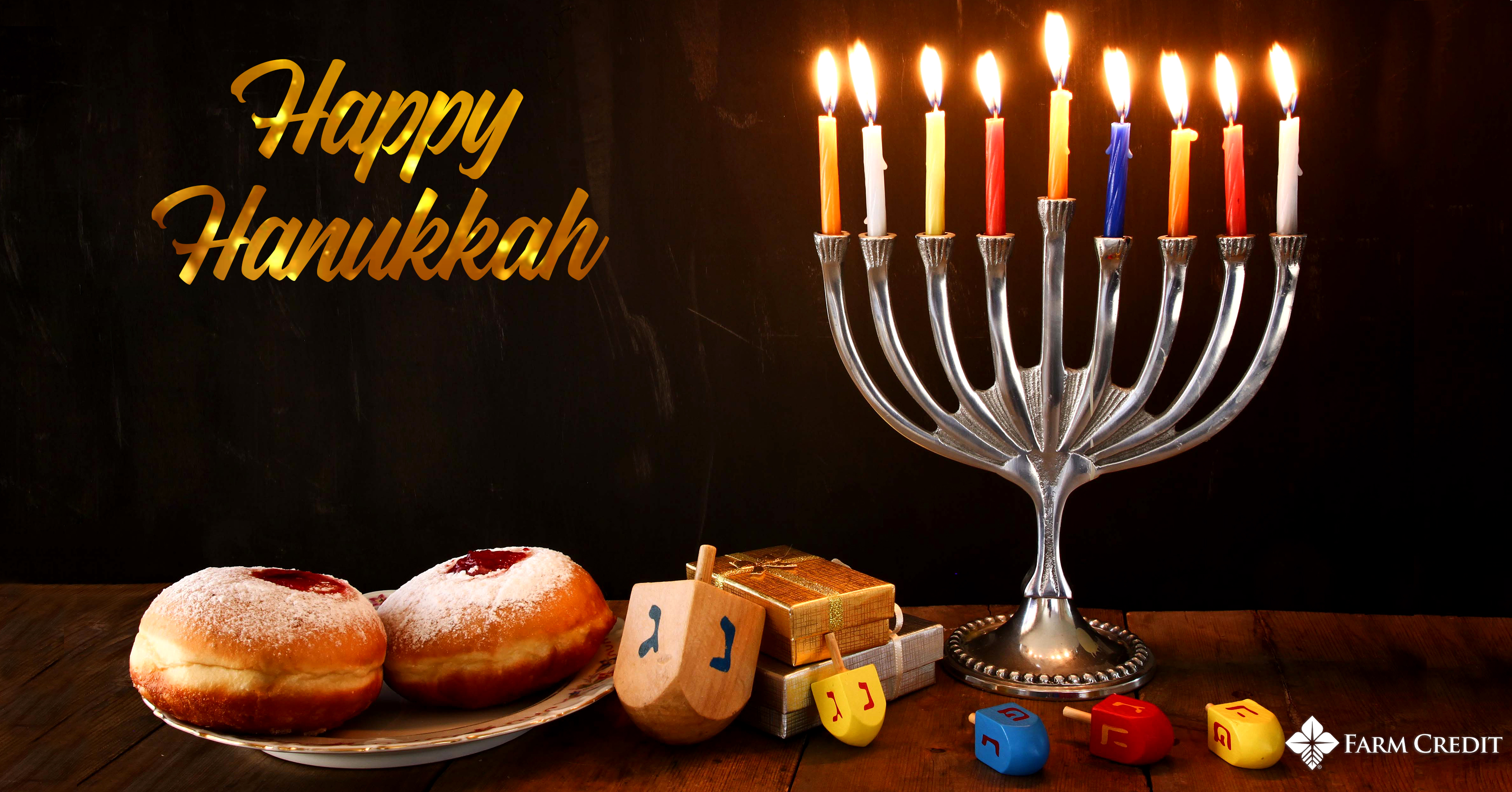 hanukka text on screen graphic with menorah lit and dreidals 