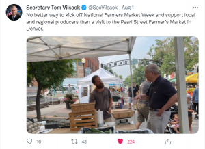 two men speaking over a table outdoors