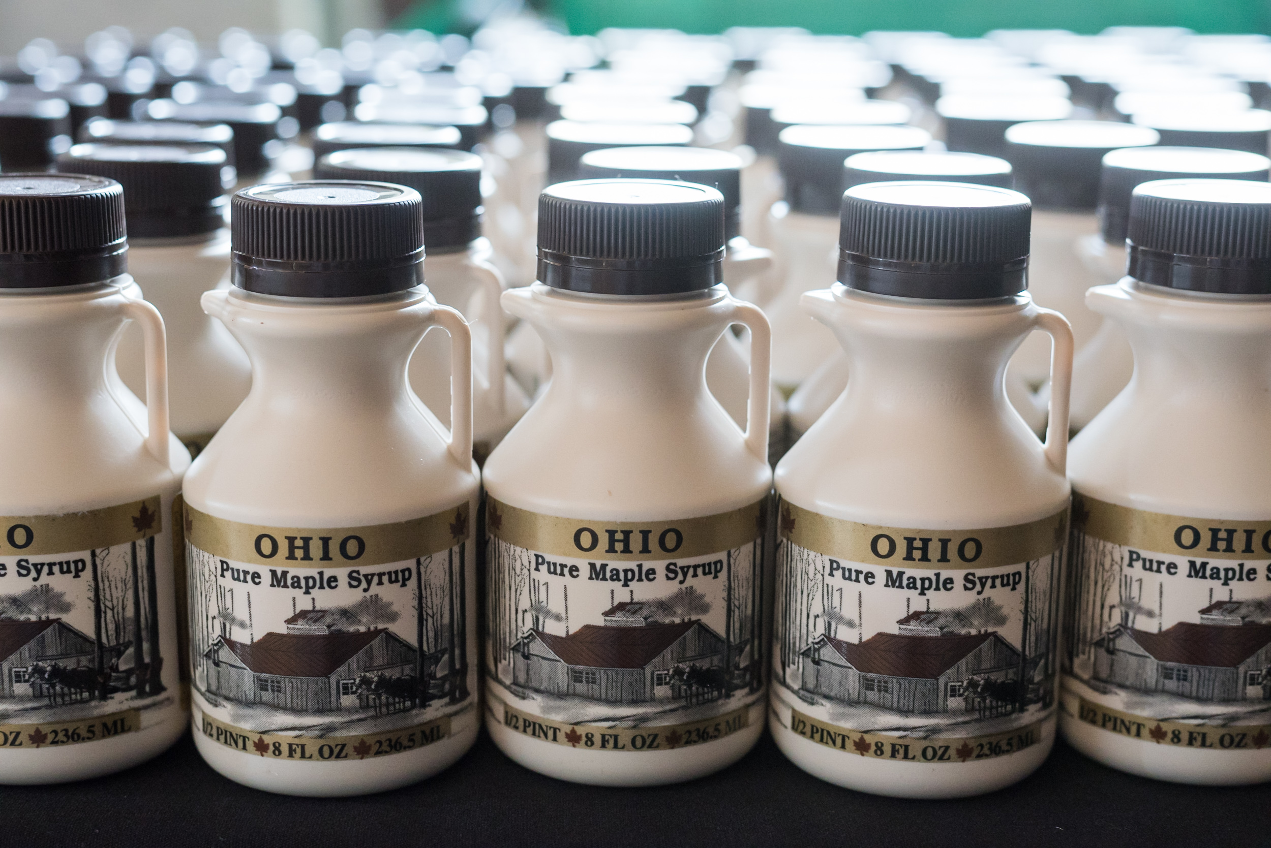 Snavely sugar shack maple syrup in white bottles lined up next to each other
