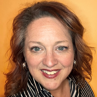 Jennifer Hatch headshot - curly brunette bob, black and white stripe blouse