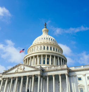 United,States,Capitol,Building,With,American,Flag,Over,Blue,Sky